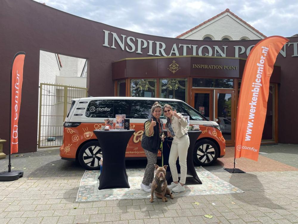 Twee medewerkers bij promotiebus van Comford