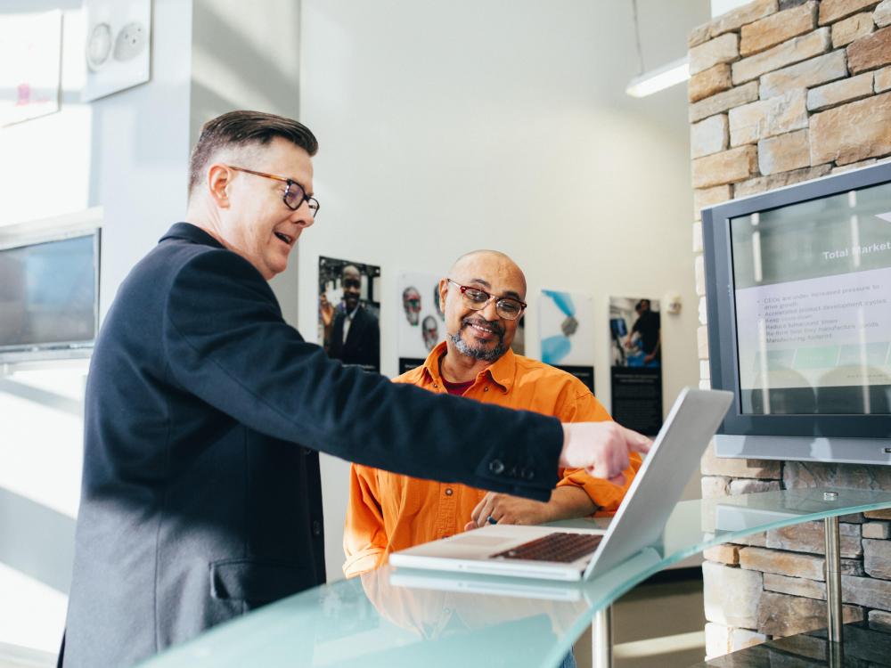Man leert andere man in de praktijk op laptop